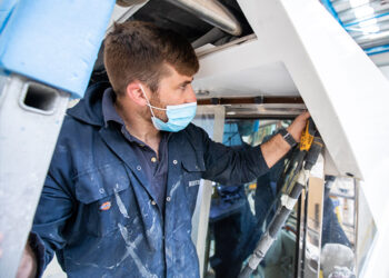 Shipwright sanding a boat prior to painting